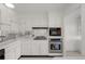 Galley-style kitchen featuring white cabinetry, mirrored backsplash, and stainless steel oven at 3131 E Alameda Ave # 1203, Denver, CO 80209