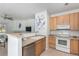 Open kitchen area with wood cabinets and a breakfast bar that overlooks the adjacent living room at 8200 E 8Th Ave # 8101, Denver, CO 80230