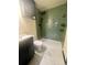 This bathroom features stylish shower with green tile, rain shower head, and new modern vanity at 3101 W Jefferson Ave, Englewood, CO 80110