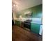 Galley kitchen featuring granite countertops, stainless steel appliances, and green cabinetry at 3101 W Jefferson Ave, Englewood, CO 80110