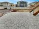 Backyard patio with stairs leading to the yard and neighboring houses in the background at 4877 Cattle Cross Rd, Castle Rock, CO 80104