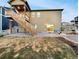 Back exterior of the home with a stairway leading to a deck and grassy backyard at 4877 Cattle Cross Rd, Castle Rock, CO 80104