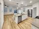 Modern kitchen with stainless steel appliances, center island with sink, and hardwood floors at 4877 Cattle Cross Rd, Castle Rock, CO 80104
