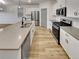 Modern kitchen with stainless steel appliances, white cabinets, a large island, and hardwood floors at 4877 Cattle Cross Rd, Castle Rock, CO 80104