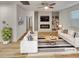 Bright, modern living room featuring a fireplace, built-in shelves, and stylish furniture on hardwood floors at 4877 Cattle Cross Rd, Castle Rock, CO 80104