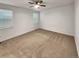 Empty primary bedroom with neutral carpet, ceiling fan, and natural light at 4877 Cattle Cross Rd, Castle Rock, CO 80104