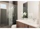 Modern bathroom with sleek glass shower, dark tiling, pebble floor, floating vanity, and white quartz countertop at 3308 W 17Th Ave, Denver, CO 80204