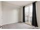 Carpeted bedroom with neutral walls, natural light from the sliding door, and modern dark curtains at 3308 W 17Th Ave, Denver, CO 80204