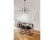 A modern dining room with a marble table, four chairs, modern art and light fixture, and hardwood floors at 3308 W 17Th Ave, Denver, CO 80204