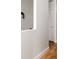 A clean hallway with white walls, white trim, hardwood floors, and view of an interior door and light fixture at 3308 W 17Th Ave, Denver, CO 80204