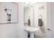 Stylish powder room featuring a pedestal sink, decorative towels, and a unique art piece at 3308 W 17Th Ave, Denver, CO 80204