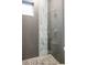 Contemporary shower with gray tile, a glass door, and a pebble-stone floor, offering a spa-like experience at 3308 W 17Th Ave, Denver, CO 80204
