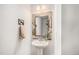 Charming half bathroom featuring a pedestal sink with a decorative mirror and fixtures at 7877 Yampa River Ave, Littleton, CO 80125
