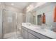 Modern bathroom boasts dual sinks, quartz countertops, tiled shower, and updated lighting at 7877 Yampa River Ave, Littleton, CO 80125
