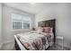Bright bedroom featuring a large window and floral bedding and a stylish wooden headboard at 7877 Yampa River Ave, Littleton, CO 80125