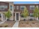 Inviting exterior of a modern townhome with stone accents and well-maintained landscaping at 7877 Yampa River Ave, Littleton, CO 80125