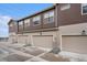 Modern townhome exterior features clean lines, attached garages, and neutral color scheme at 7877 Yampa River Ave, Littleton, CO 80125