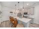 Bright kitchen boasts a spacious island, modern pendant lighting, and stainless steel appliances at 7877 Yampa River Ave, Littleton, CO 80125