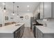 Modern kitchen with gray cabinets, quartz countertops, stainless steel appliances, and an island at 7877 Yampa River Ave, Littleton, CO 80125