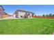 The expansive backyard features a lush green lawn, a wooden fence, and a charming deck at 8020 E 136Th Dr, Thornton, CO 80602