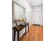 Inviting entryway featuring hardwood floors, decorative mirror, console table and view of the front door at 8020 E 136Th Dr, Thornton, CO 80602