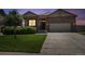 Charming single-Gathering home with a well-manicured lawn and inviting front entrance, plus a two car garage at twilight at 8020 E 136Th Dr, Thornton, CO 80602