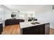 Open kitchen showcasing an island with stainless steel appliances flowing into the adjacent living room at 8020 E 136Th Dr, Thornton, CO 80602