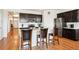Modern kitchen with stainless steel appliances, dark cabinets, and a large island with bar seating at 8020 E 136Th Dr, Thornton, CO 80602
