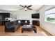Cozy living room featuring hardwood floors, a comfortable couch, a ceiling fan and a mounted television at 8020 E 136Th Dr, Thornton, CO 80602