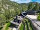 Stunning modern home featuring mountain views, tiered landscaping, and a sleek black exterior with an attached garage at 365 Bow Mountain Rd, Boulder, CO 80302