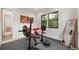 Bright home gym featuring weight training equipment, rubber flooring, and views of a wooded backyard through black-framed windows at 365 Bow Mountain Rd, Boulder, CO 80302
