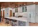 Modern kitchen features sleek white cabinetry, stainless steel appliances, a beverage fridge, and island seating at 365 Bow Mountain Rd, Boulder, CO 80302