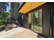 A concrete patio features a sliding glass door, black accents, and access to a grassy hillside at 365 Bow Mountain Rd, Boulder, CO 80302