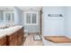 Well-lit bathroom featuring a vanity, toilet, walk-in shower, and bright window at 5722 S Benton Way, Littleton, CO 80123