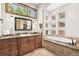 A luxurious bathroom features dual sinks, granite countertops, and a soaking tub with garden views at 5722 S Benton Way, Littleton, CO 80123