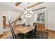 Elegant dining room with exposed beam ceiling, modern chandelier, and views of the staircase at 5722 S Benton Way, Littleton, CO 80123