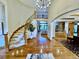 Grand foyer boasts a curved staircase, high ceilings, and gleaming hardwood floors at 5722 S Benton Way, Littleton, CO 80123