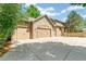 Spacious three-car garage with stone accents and a large driveway at 5722 S Benton Way, Littleton, CO 80123