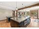 A gourmet kitchen featuring a stainless steel island, pendant lighting, and access to an outdoor patio area at 5722 S Benton Way, Littleton, CO 80123
