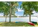 Scenic view of a calm lake framed by trees and canoes on the grassy shore at 5722 S Benton Way, Littleton, CO 80123