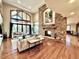 Bright living room with a stone fireplace, hardwood floors, and large windows at 5722 S Benton Way, Littleton, CO 80123