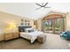 A serene bedroom featuring a vaulted ceiling, backyard views, and stylish decor for a relaxing retreat at 5722 S Benton Way, Littleton, CO 80123