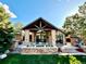 Covered patio with a stone fireplace and comfortable seating area for entertaining at 5722 S Benton Way, Littleton, CO 80123