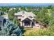 A luxurious home featuring a covered outdoor living space with a fire pit and well-manicured lawn at 5722 S Benton Way, Littleton, CO 80123
