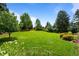 Large, green backyard with mature trees and flower beds, offering a serene and private outdoor space at 5698 Green Oaks Dr, Greenwood Village, CO 80121