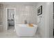 Bright bathroom featuring a soaking tub with decor, marble tiling, and modern fixtures at 5698 Green Oaks Dr, Greenwood Village, CO 80121