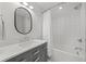 Well-lit bathroom with a modern vanity, mirror, and a shower-tub combo with white tile surround at 5698 Green Oaks Dr, Greenwood Village, CO 80121