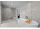 Luxurious bathroom with marble tiling, walk-in shower, and freestanding soaking tub at 5698 Green Oaks Dr, Greenwood Village, CO 80121
