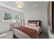 Bright bedroom with a large window, comfortable bed, dresser, and modern decor at 5698 Green Oaks Dr, Greenwood Village, CO 80121