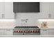 Bright kitchen featuring stainless steel stove with red knobs, a pot filler above the cooktop, and white subway tile backsplash at 5698 Green Oaks Dr, Greenwood Village, CO 80121